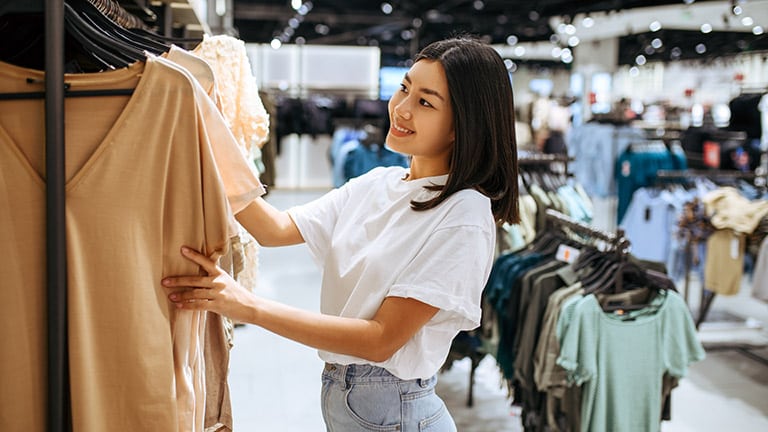 Woman shopping in a discount clothing store like Discovery Clothing Company.