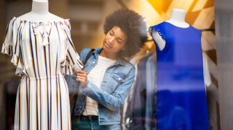 Young woman shopping for dresses.
