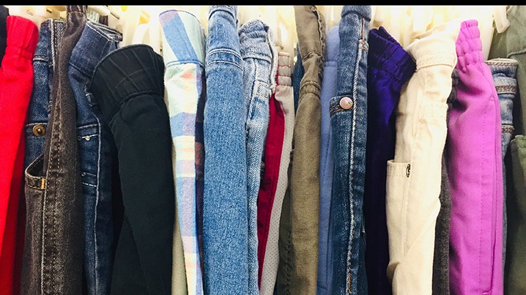 Clothes hanging on a rack to represent how to shop Goodwill