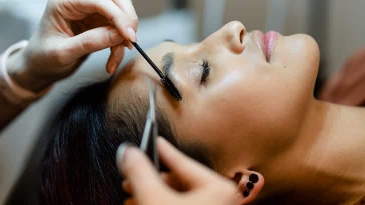 Woman getting eyebrow treatment to represent Booksy review.