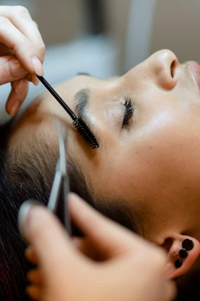 Woman getting eyebrow treatment to represent Booksy review. 