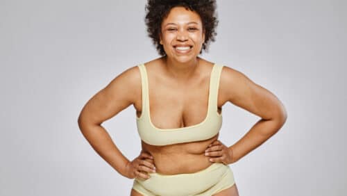 3 essential quick tips for dressing your pear shape 1 Woman with pear-shaped body wearing underwear smiles.