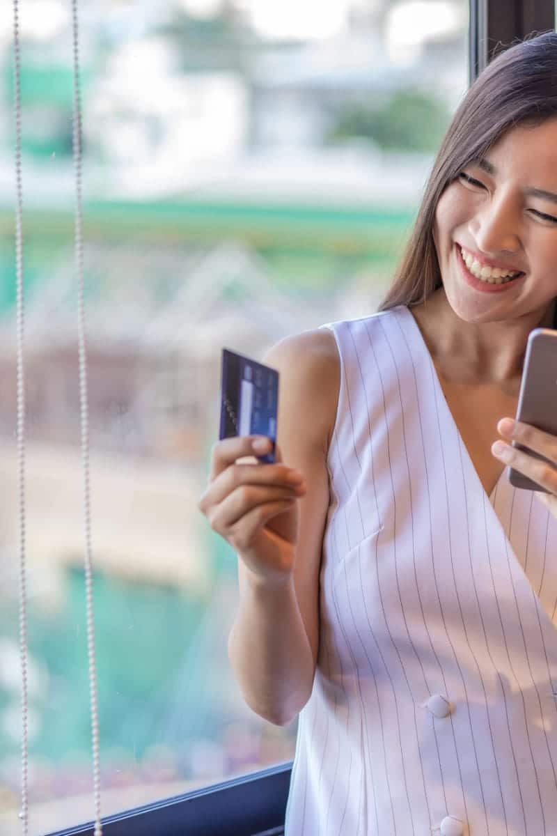 Woman smiles as she shops online at Gilt.