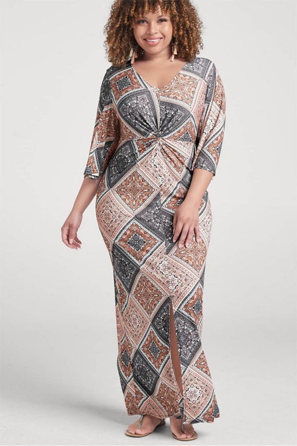 Model wears patterned maxi dress in plus size.