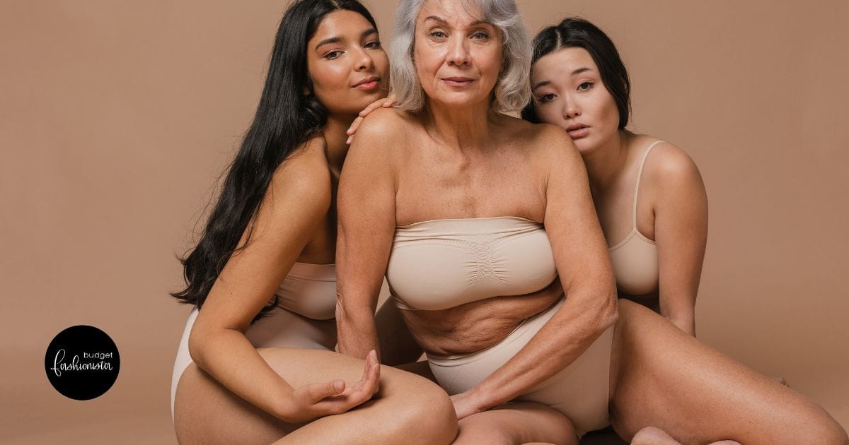 Diverse group of three woman pose in underwear against beige backdrop.