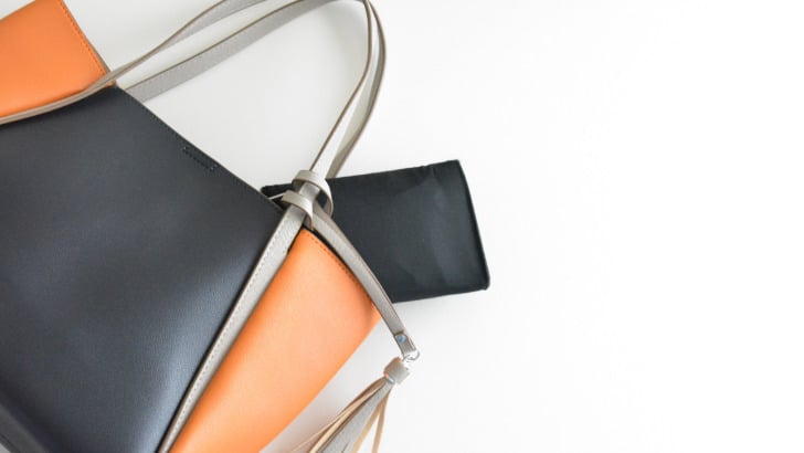 Stylish purse with colorblock design laying on its side.