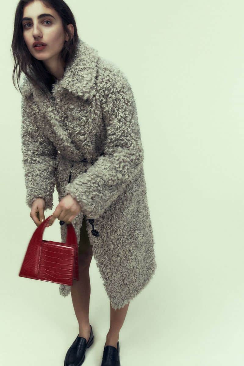 Model holds red trendy bag from Zara.