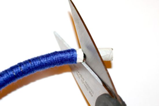 Scissors cutting end of rope