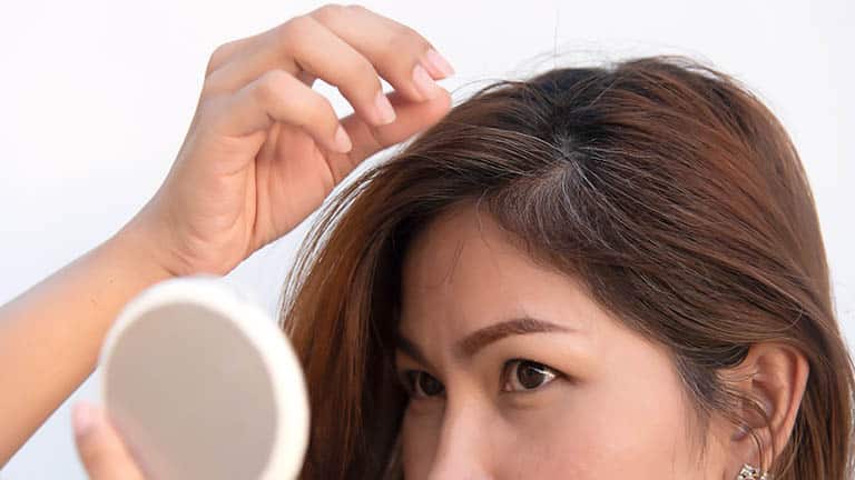 Close up of woman with natural and dyed hair colors.