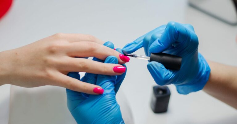 Close-up view of professional manicure with red nail polish.