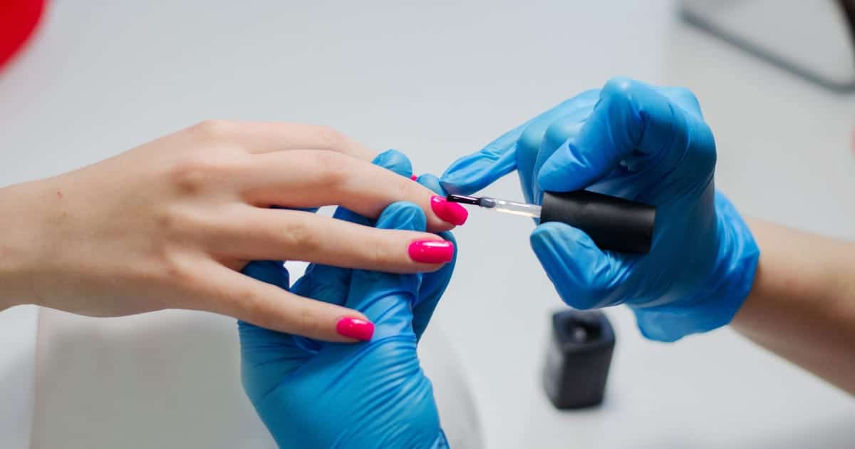 Close-up view of professional manicure with red nail polish.