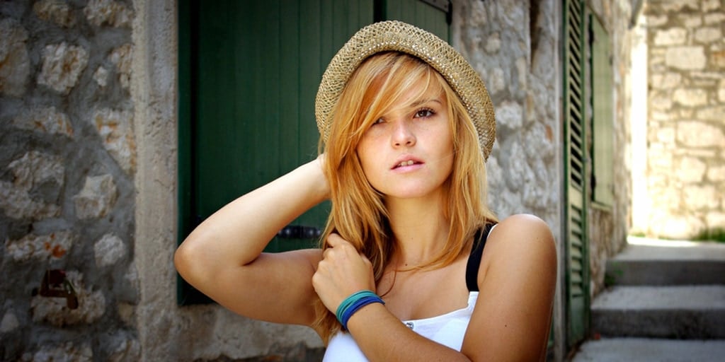 Woman with side swept bangs and hat