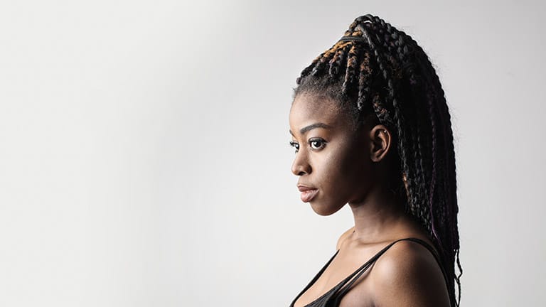 Close up of woman with braids pulled into half-up, half-down style.