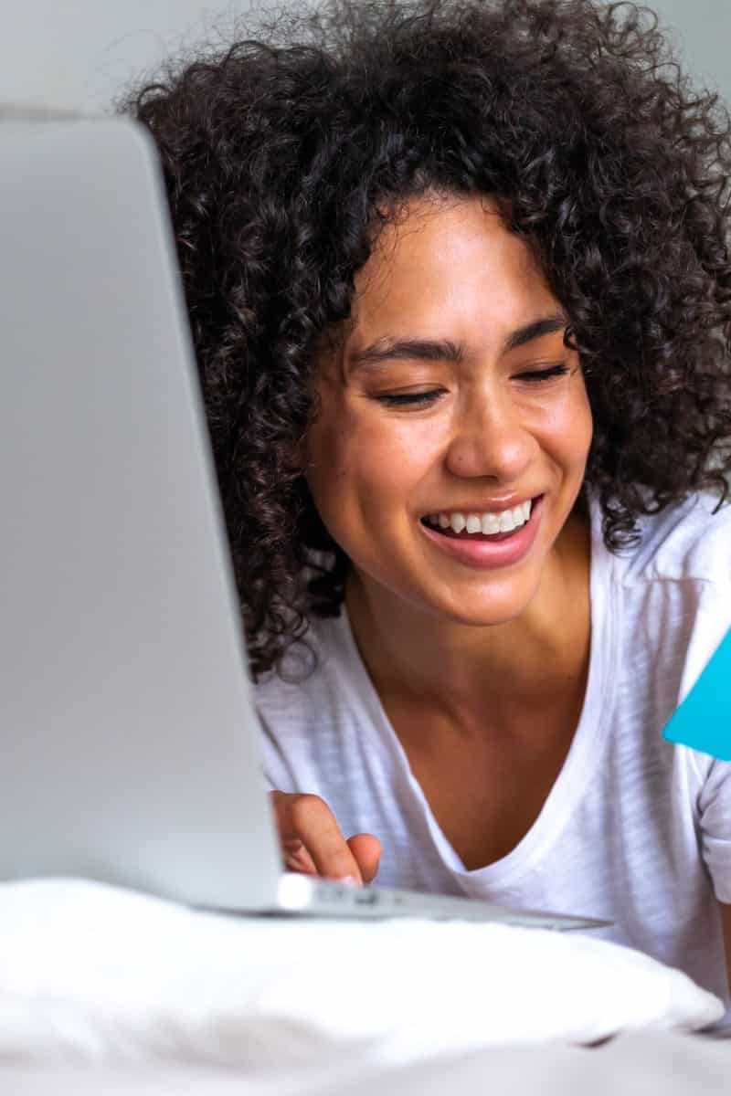 Why Shop Amazon? 11 Answers 1 Smiling woman shopping online to represent why shop Amazon.