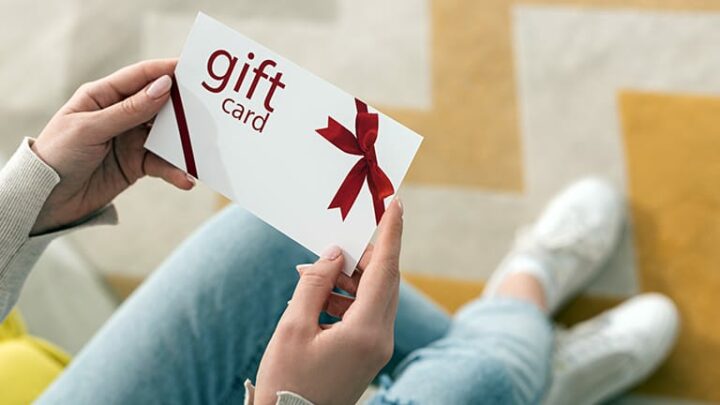Close up of woman holding top gift card.