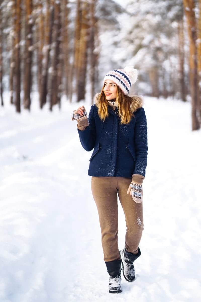 5 Winter Jackets that Look Great with Everything 1 Woman wearing winter jacket outside in the snow.
