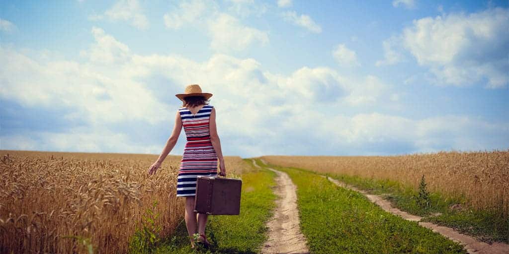 Woman wearing striped dress and hat in a field