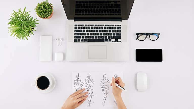 Close up of fashion designer drawing sketches.