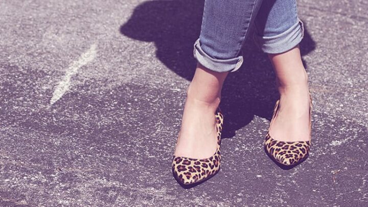 Close-up of woman's feet wearing animal print shoes.
