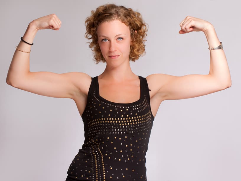 woman holding her arms up to show biceps
