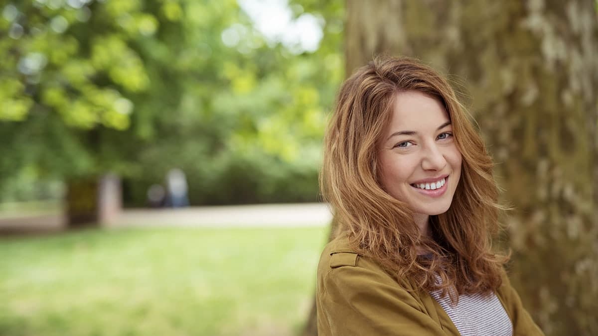 Woman smiling standing in park