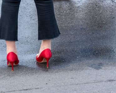 Woman wearing flared jeans and red heels