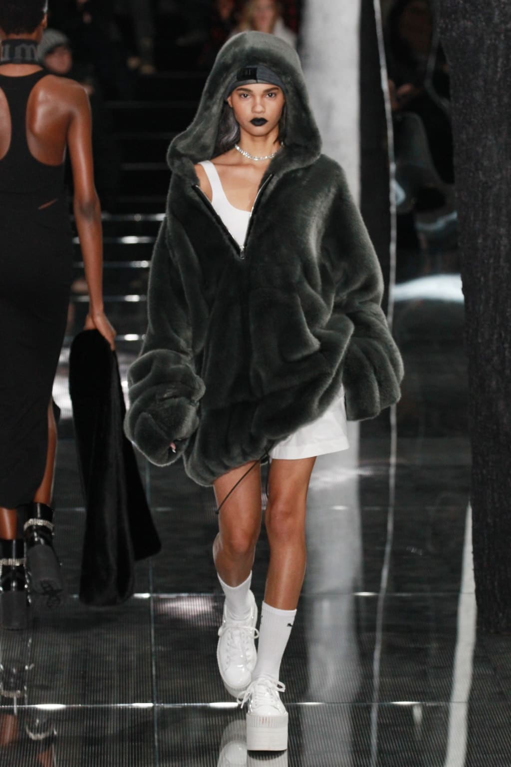 Model on runway wearing fur coat