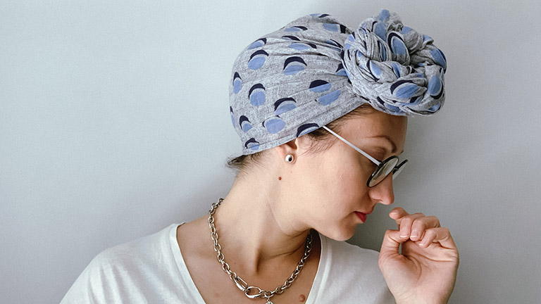 Close-up of woman wearing tied headscarf.