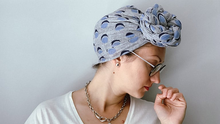 How to Wear a Headscarf 6 Ways 1 Close-up of woman wearing tied headscarf.