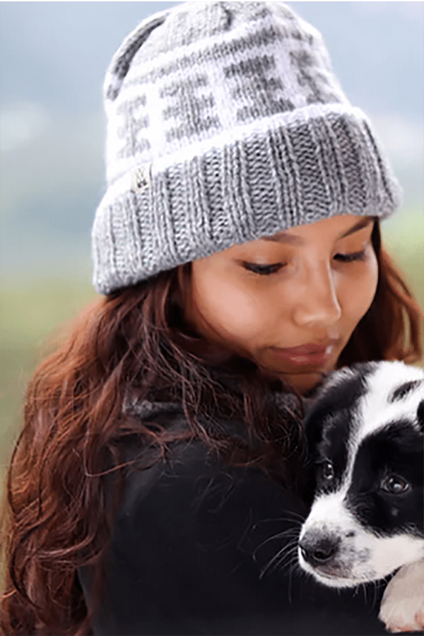 Give Good: 9 Charity Gifts Fashion Enthusiasts will Love 3 Woman holding puppy wears knit beanie from charity brand Fazl.