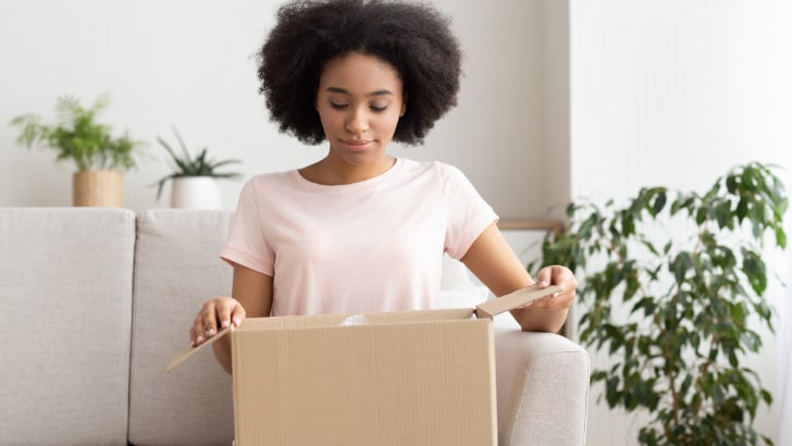 Woman opens box from online order.