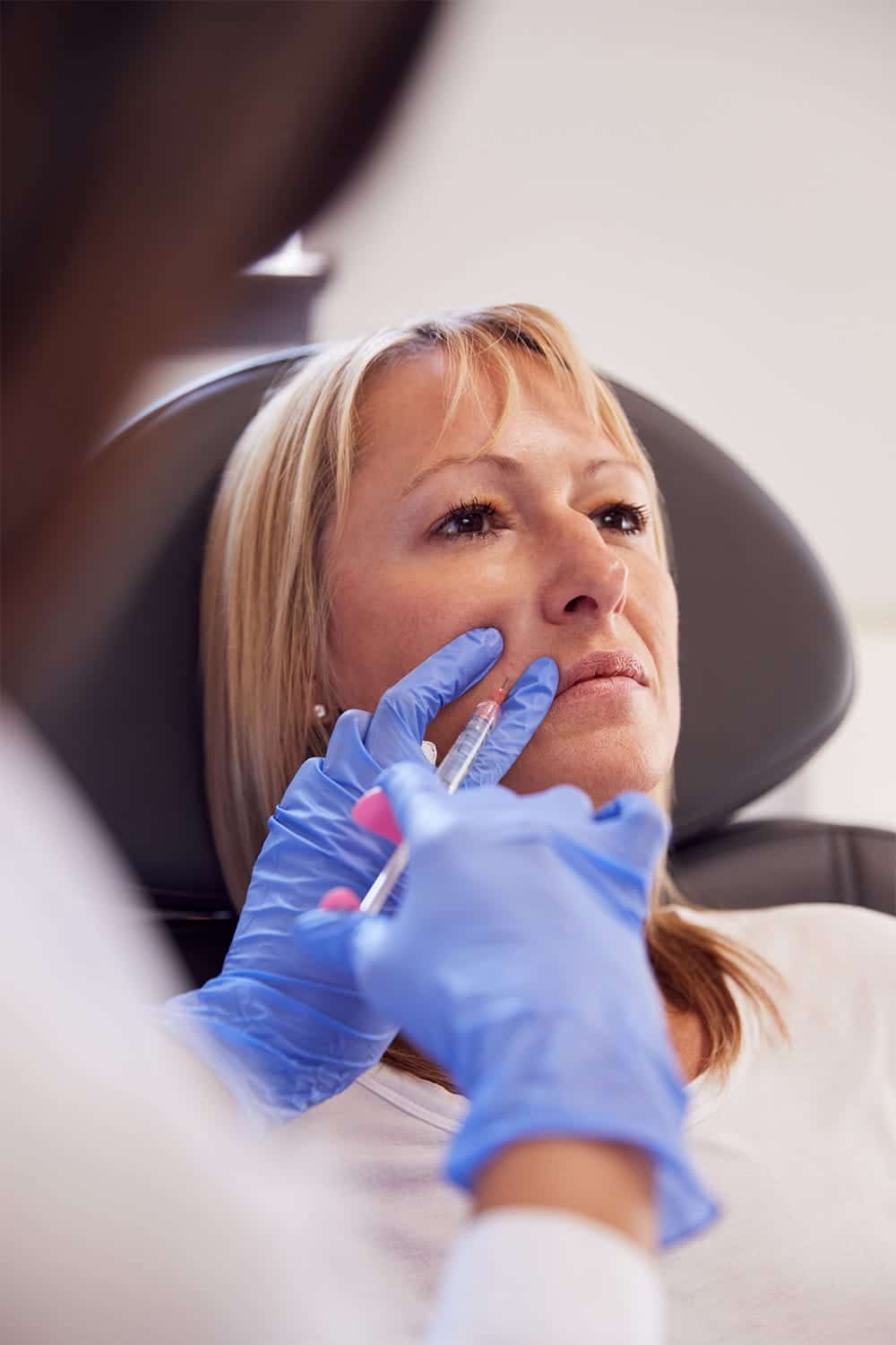 Help! What Can I Do About Early Signs of Aging? 1 Woman with early signs of aging gets Botox injection.