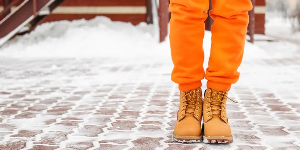 Close up of woman wearing orange pants and lug boots