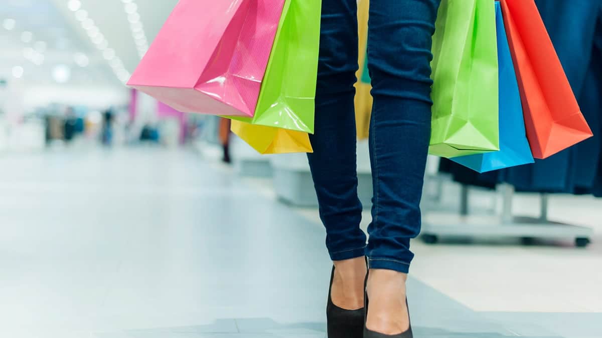 Woman with shopping bags, practicing retail therapy.
