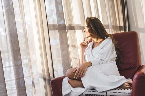 Woman sitting in chair wearing bathrobe