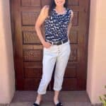 Catherine Brock wearing white pants, patterned top, and flats.