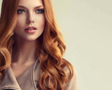 Woman with red hair set in loose curls