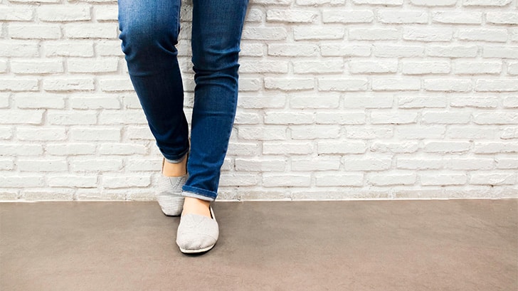 Close up view of women's lower legs, wearing jeans.