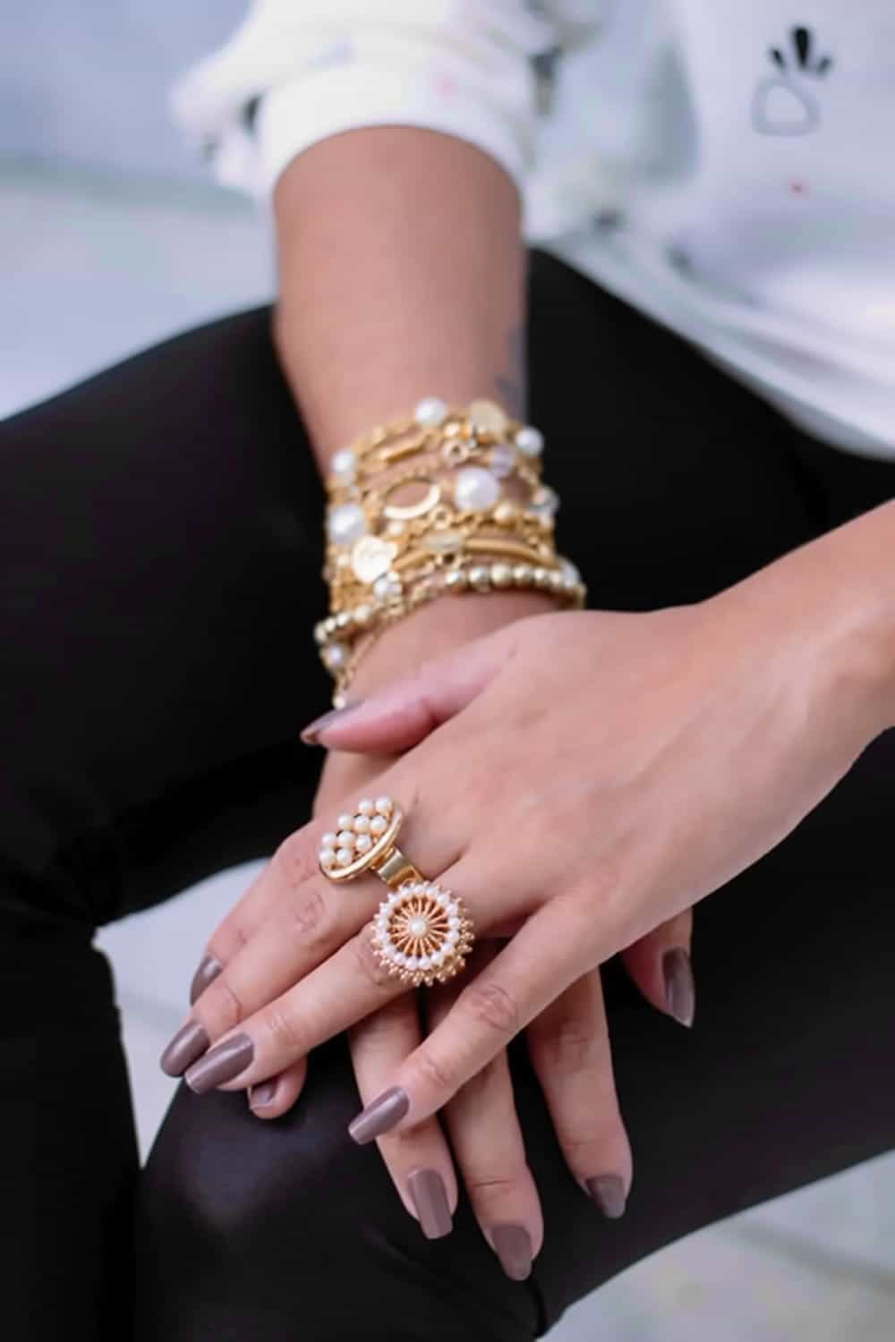 Close up of woman's hands with stacked rings and bracelets