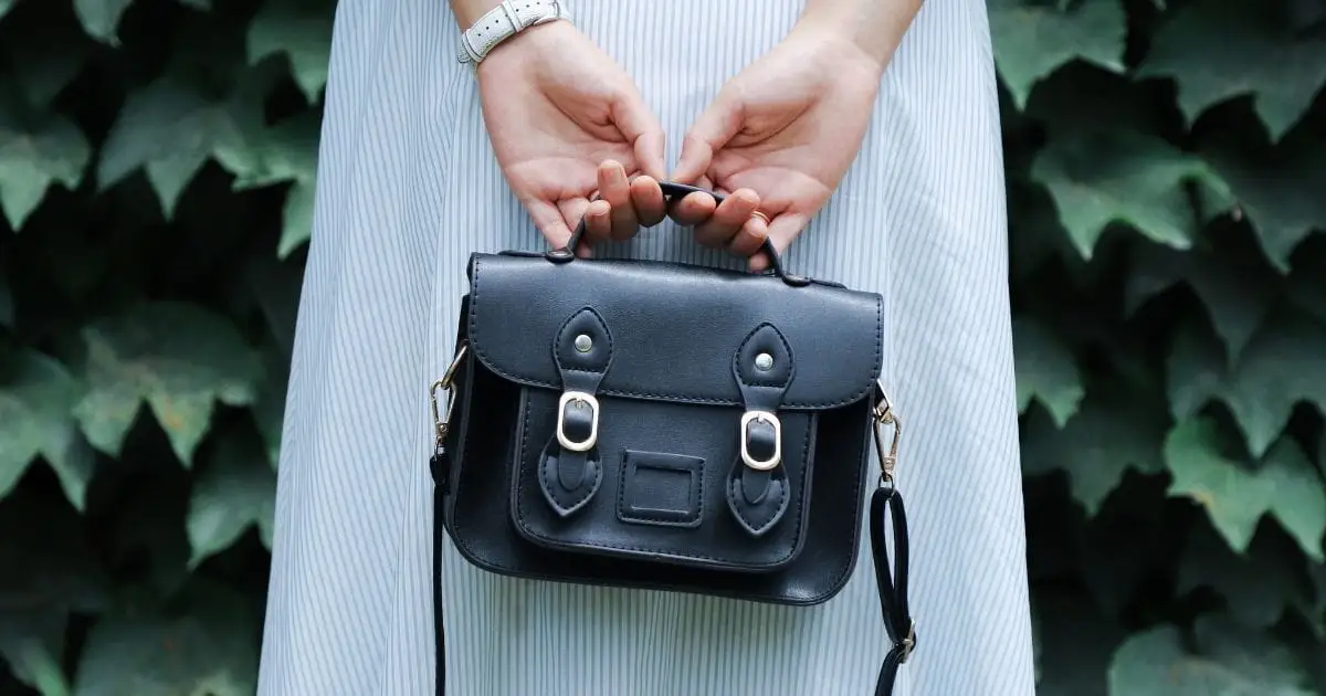 Woman holding handbag behind her back.