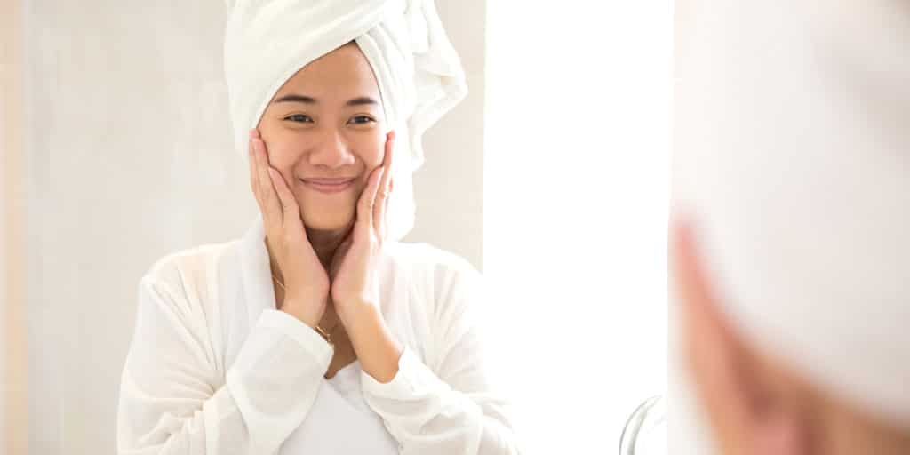 Woman looking in the mirror in the bathroom