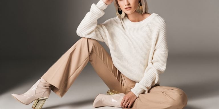 Woman wearing neutral tones and sitting on the floor
