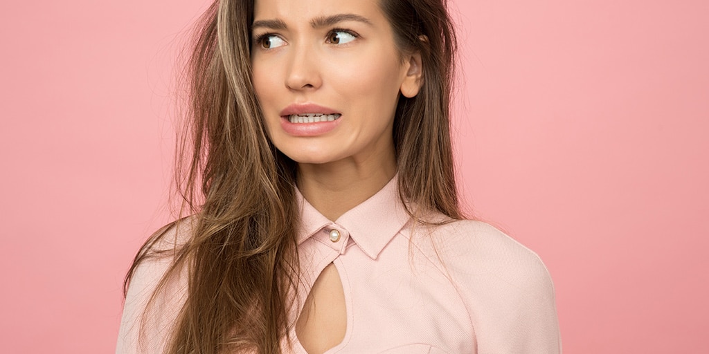 Woman in button down blouse making face