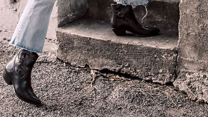 View of women's legs wearing cowboy boots.