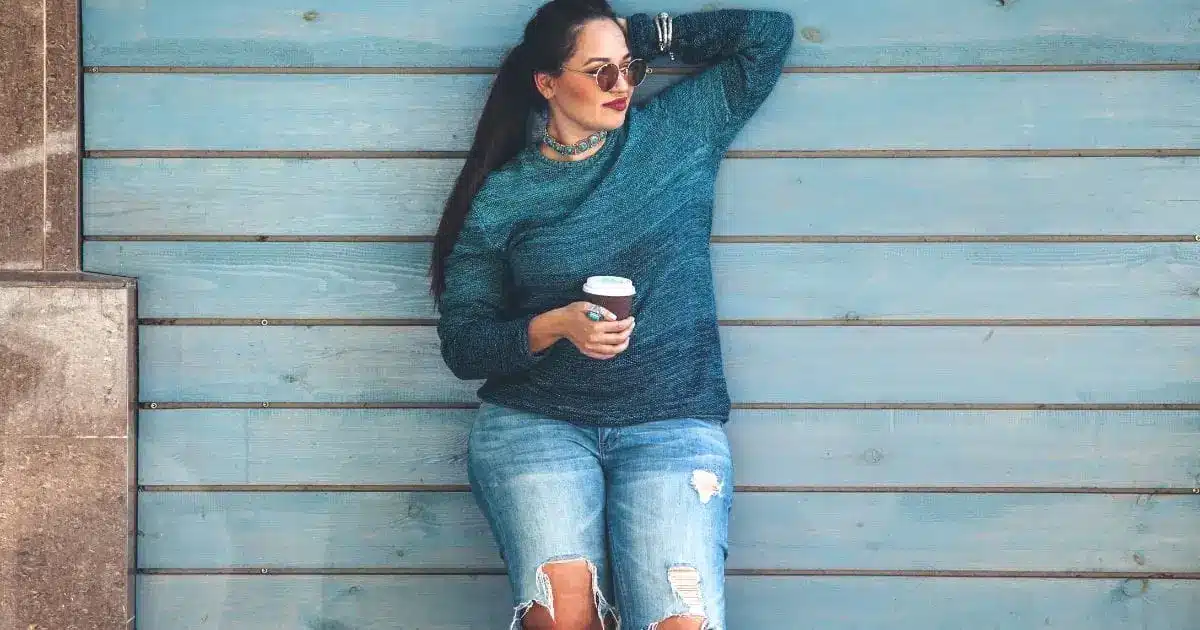 Plus-size model against planked wall.