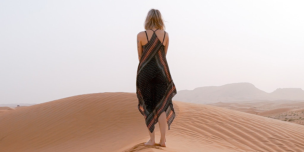 Woman wearing handkerchief hem dress on sand dunes