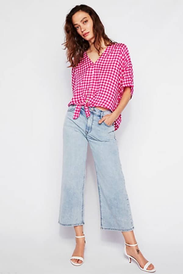 Woman wearing bright pink gingham top with tie front
