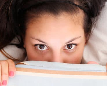Woman hiding under covers