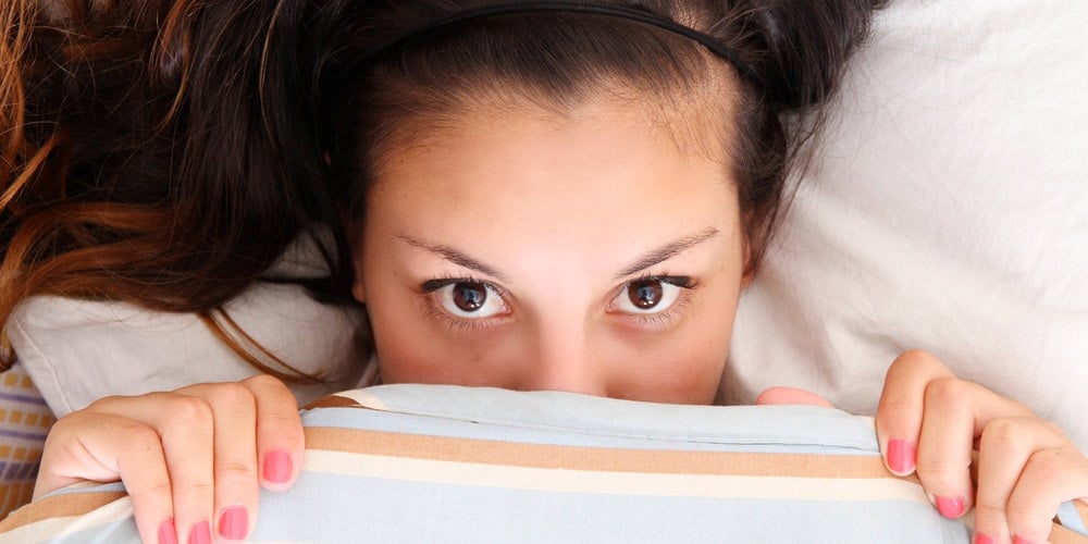 Woman hiding under covers