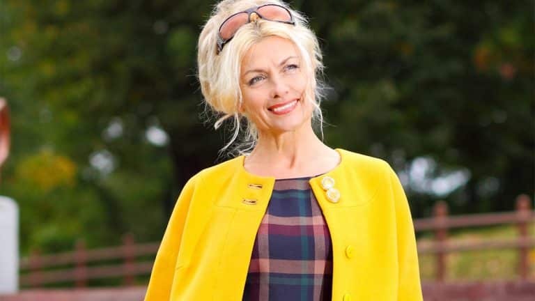 Older woman wearing fashionable bright coat and plaid dress